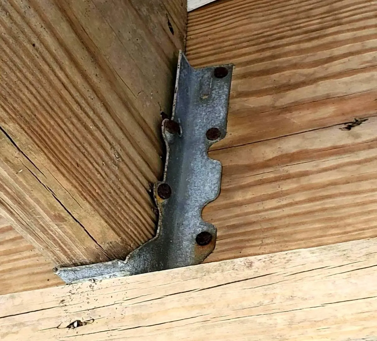 Joist hanger bracket with rusted fasteners